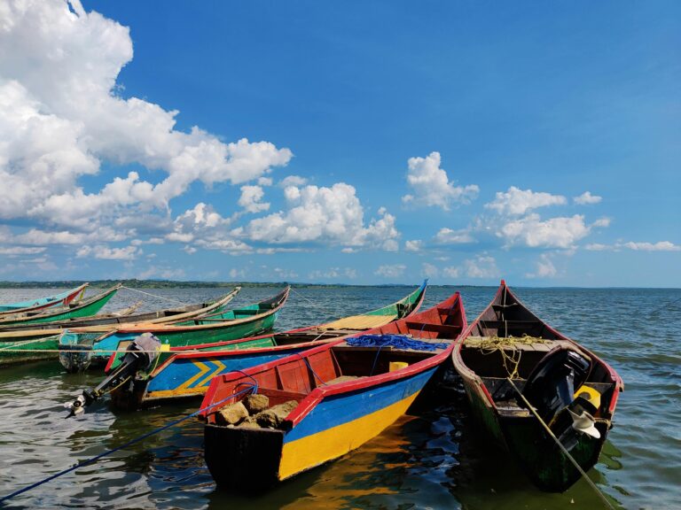 Vibrant wooden boats on Lake Victoria under a bright blue sky in Migori, Kenya.
