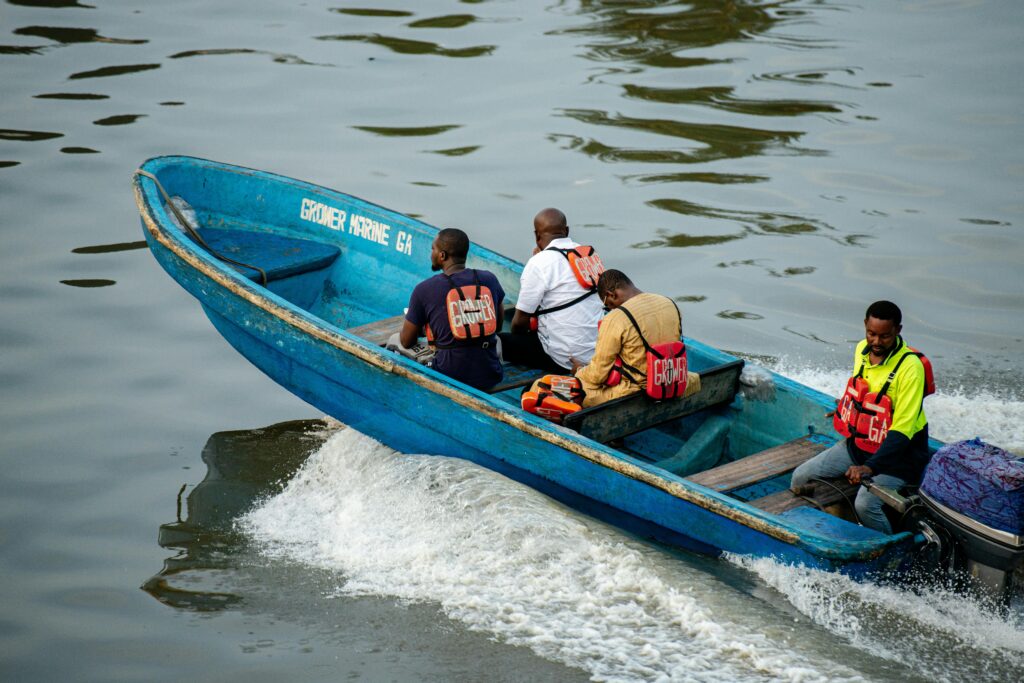 Group of men in a blue motorboat navigating the waters of Lagos, Nigeria.