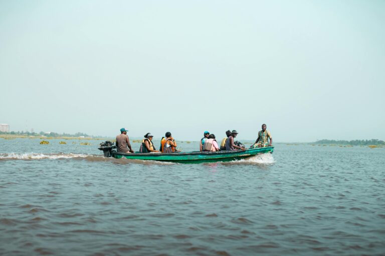 A group of people navigate a traditional boat on Badagry Lagoon, Nigeria.