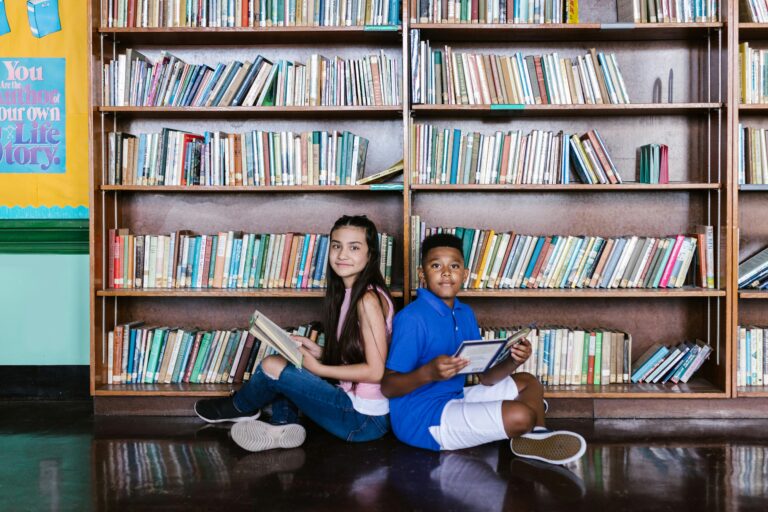 Two children reading books in a school library, fostering learning and diversity.