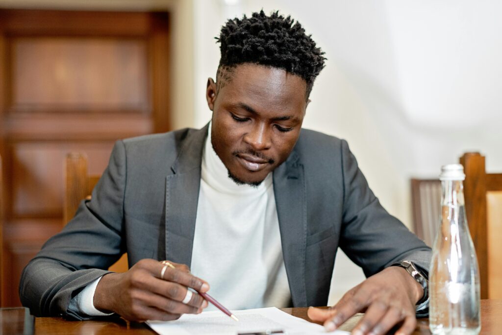 Businessman signing documents in a formal setting, focused on paperwork.